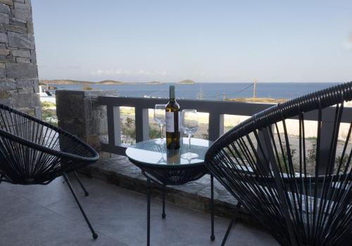 a table with a bottle of wine and two chairs at Aegeans Eye in Azolimnos
