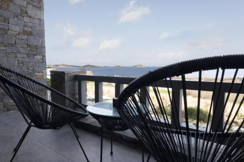 two chairs on a balcony with a view of the ocean at Aegeans Eye in Azolimnos