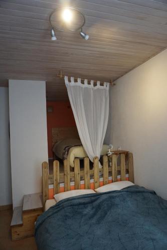 een slaapkamer met een groot bed en een gordijn bij GITE AUBERGE DU BUECH à ASPREMONT- 05 HAUTES ALPES in Aspremont