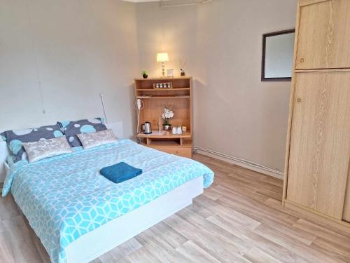1 dormitorio con 1 cama con edredón azul en Eenvoudige slaapkamer Geraardsbergen, en Geraardsbergen