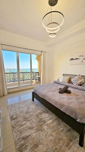 a bedroom with a bed and a large window at Beach Apartment in Ras al Khaimah
