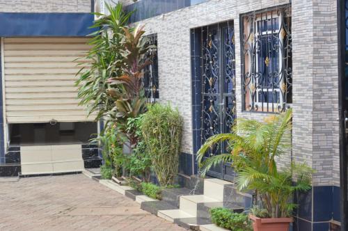 un bâtiment avec des plantes devant une porte dans l'établissement DF HOTEL plazza, à Yaoundé