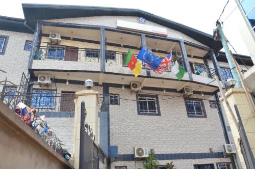 un bâtiment avec des drapeaux sur son côté dans l'établissement DF HOTEL plazza, à Yaoundé