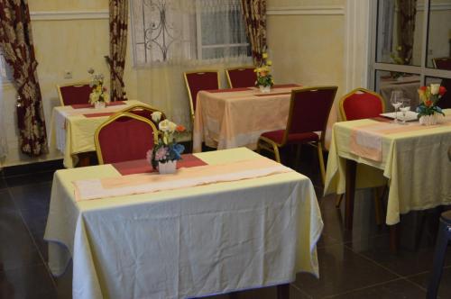 ヤウンデにあるDF HOTEL plazzaのテーブル2台と椅子(黄色のテーブルクロス付)が備わる客室です。