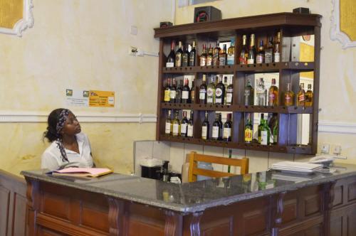 une femme assise au comptoir d'un bar dans l'établissement DF HOTEL plazza, à Yaoundé