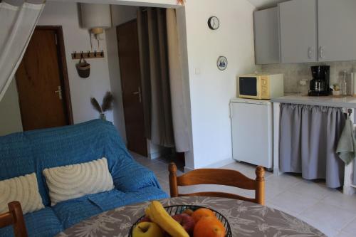 une cuisine avec une table avec un bol de fruits dessus dans l'établissement Lou Pitchoun Cabanoun à Eygalières 