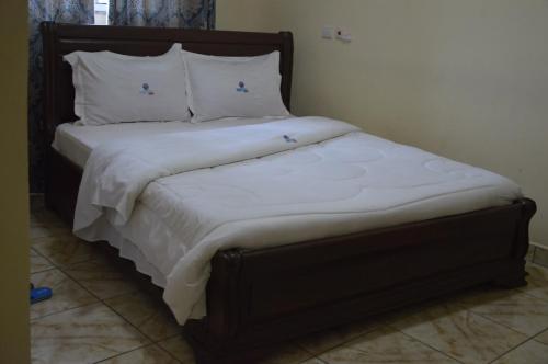 ヤウンデにあるDF HOTEL plazzaのベッド(白いシーツ、枕付)