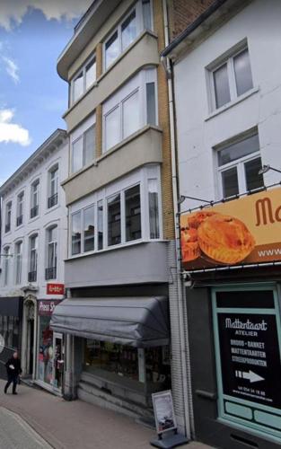 un edificio con un cartello della pizza sul lato. di Eenvoudige slaapkamer Geraardsbergen a Geraardsbergen