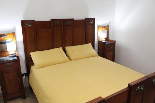 een slaapkamer met een bed met gele lakens en 2 verlichting bij Villa Corvetta in Ostuni
