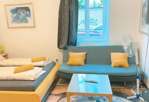 ein Wohnzimmer mit einem blauen Sofa und einem Ventilator in der Unterkunft Studio in City center KM3a in Wien