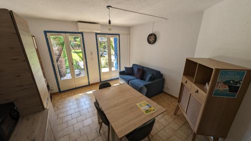 un salon avec une table et un canapé bleu dans l'établissement Magnifique T2 - Santa Cruz 62, à Canet