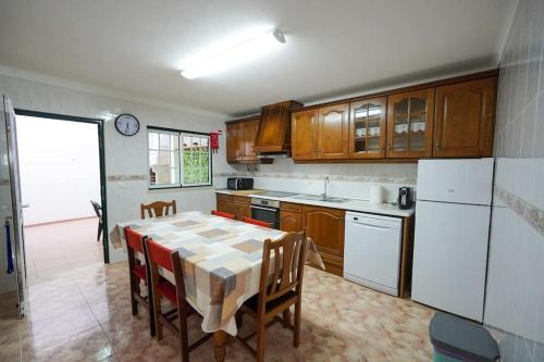 cocina con mesa y nevera blanca en Casa do Largo, en Nazaré