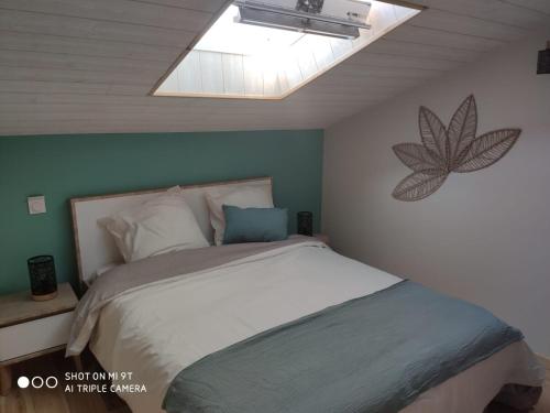 une chambre avec un grand lit avec une lucarne dans l'établissement Gîte Les Cardoux, à Monguyard