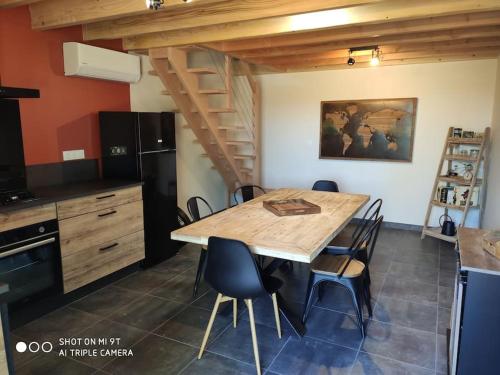 une cuisine avec une table et des chaises en bois dans l'établissement Gîte Les Cardoux, à Monguyard