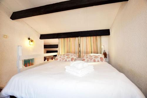 une chambre avec un grand lit blanc avec une fenêtre dans l'établissement Appartement Cosy vue mer au Cœur de Port Leucate, à Leucate