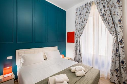 una camera da letto con pareti blu e un letto con due cuscini di The Space Rooms a Roma