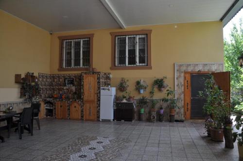 a room with a yellow wall with a table and a refrigerator at Загородный дом в горах, Габала in Corat