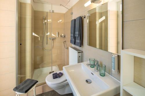 uma casa de banho com um lavatório, um WC e um chuveiro em Hotel Garni dei fiori em Ascona