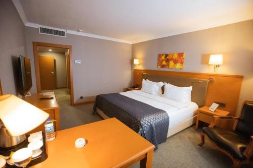 a hotel room with a large bed and a table at La Quinta by Wyndham Giresun in Giresun
