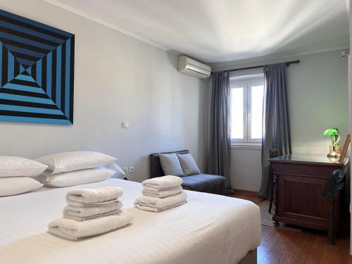 een slaapkamer met een bed met handdoeken erop bij "San Giacomo Square Apt." in the heart of old town in Corfu-stad