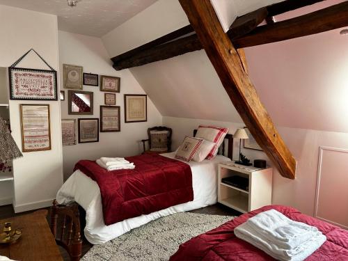 ル・ヴィガンにあるLe Vallonnet Gîte classé 5 étoilesのベッドルーム(ベッド2台付)が備わる屋根裏部屋です。