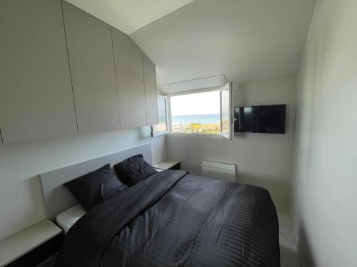 une petite chambre avec un lit et une fenêtre dans l'établissement Bleu horizon, à Courseulles-sur-Mer