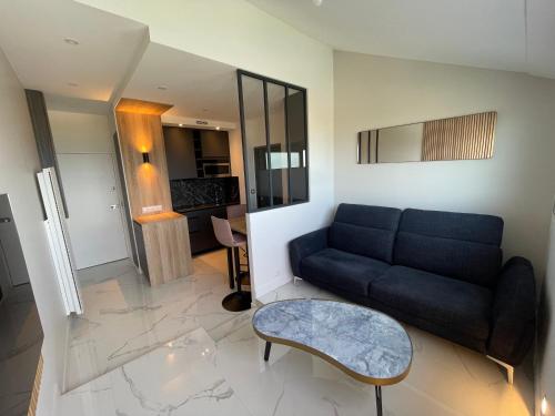 un salon avec un canapé et une table dans l'établissement Bleu horizon, à Courseulles-sur-Mer