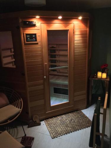 une armoire en bois avec une porte en verre dans une pièce dans l'établissement love Cévennes, à Alès