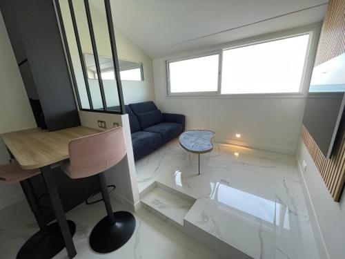 - un salon avec un canapé bleu et un bureau dans l'établissement Bleu horizon, à Courseulles-sur-Mer