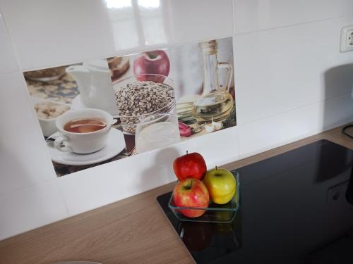a table with a bowl of apples and cups of coffee at Wohlfühlwohnung in Rappottenstein