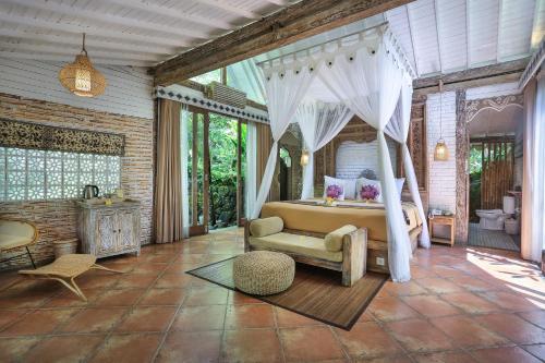 - une chambre avec un lit à baldaquin dans l'établissement Pramana Giri Kusuma, à Payangan