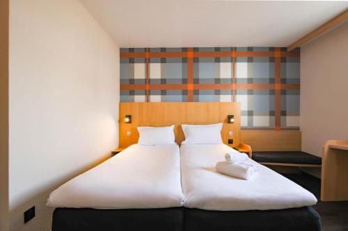 a bedroom with a large white bed with two pillows at easyHotel Nice Old Town in Nice