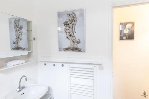 une salle de bain blanche avec un lavabo et un miroir dans l'établissement Montmartre Apartments - Degas, à Paris