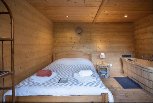 a bedroom with a bed in a wooden cabin at 1000 Borne Caffe Hebergements Insolites in Entremont