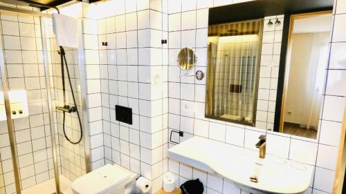 ビリャホヨサにあるPou by Seaward Suites Only Adultsのバスルーム(トイレ、洗面台、鏡付)
