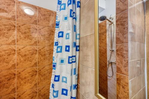 a shower with a shower curtain in a bathroom at Apartments Marija 1000 in Rabac