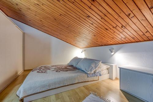 sypialnia z łóżkiem i drewnianym sufitem w obiekcie Apartments Marija 1000 w Rabacu