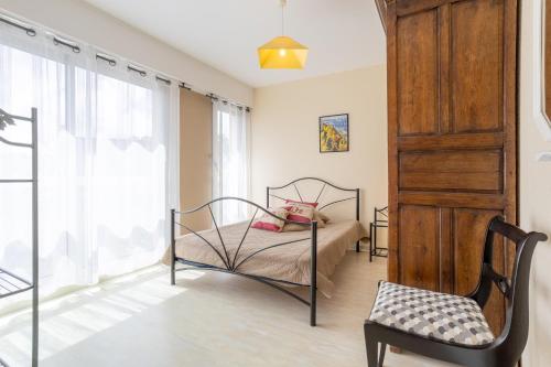een slaapkamer met een bed en een stoel bij Appartement Le Croas Men in Douarnenez