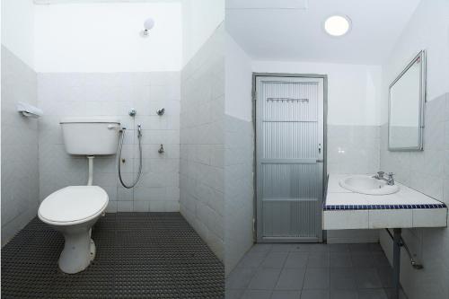 uma casa de banho branca com um WC e um lavatório em OYO 90089 N H Inn em Rumah Imba