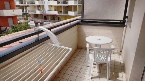a balcony with a table and a chair on a building at B&B Hotel Fattoriamare in Alba Adriatica
