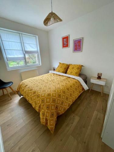 - une chambre avec un lit doté d'un couvre-lit jaune et 2 fenêtres dans l'établissement Belle maison proche mer Sangatte Blériot-plage, à Sangatte