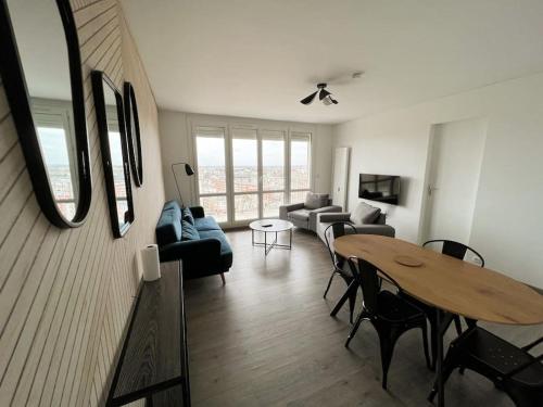 un salon avec un canapé et une table dans l'établissement Une chambre privée bleu dans un appartement partagé, à Orléans