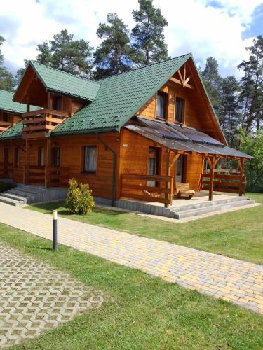 a large wooden house with a green roof at Nad Strumykiem in Koszele