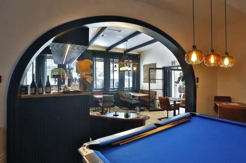 a pool table in a living room with an arch at Hotel L'ermitage in Houffalize