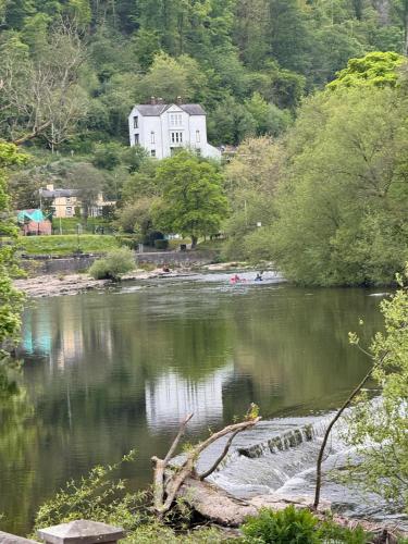 a white house sitting on the side of a river at Bala Holiday Suites in Bala