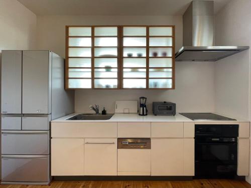 a kitchen with white cabinets and a sink at 葉山 - Nowhere but Hayama in Hayama