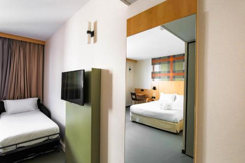a hotel room with two beds and a television at easyHotel Nice Old Town in Nice
