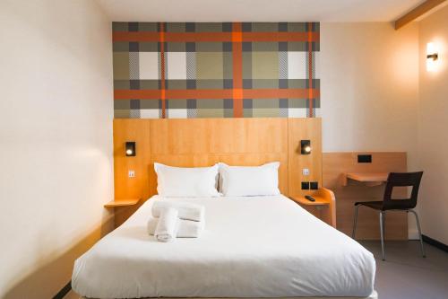 1 dormitorio con 1 cama con 2 toallas en easyHotel Nice Palais des Congrès – Old Town, en Niza