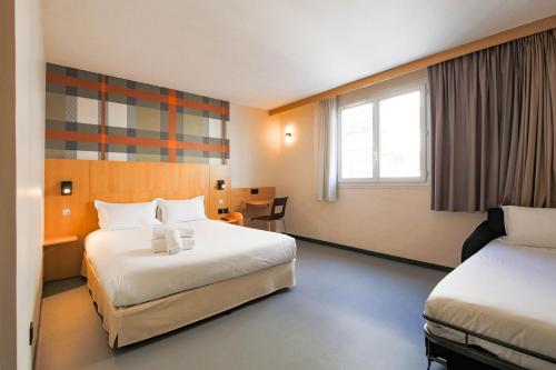 a hotel room with two beds and a desk at easyHotel Nice Palais des Congrès – Old Town in Nice