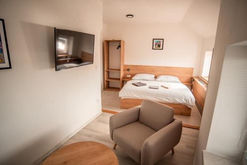 um pequeno quarto com uma cama e uma cadeira em APART Mikeš em Telč